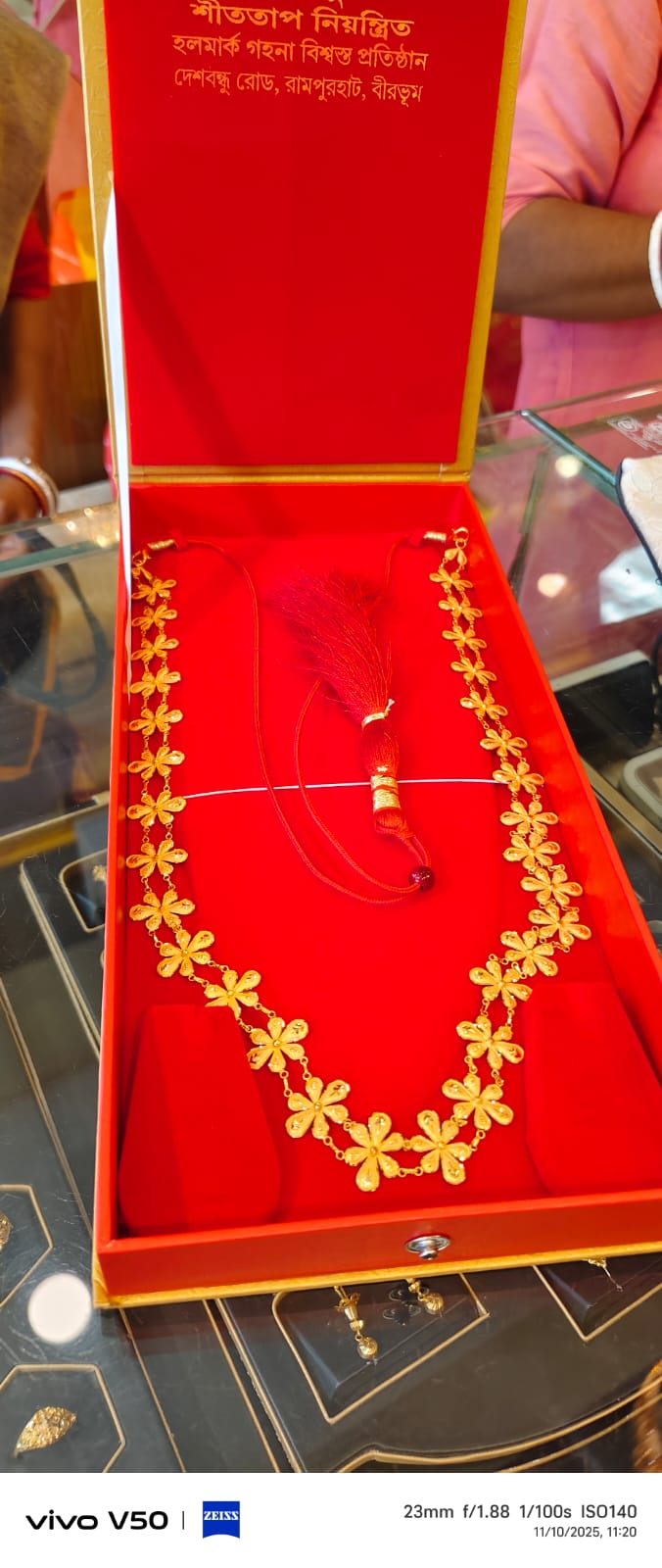 Floral gold necklace displayed in red velvet box